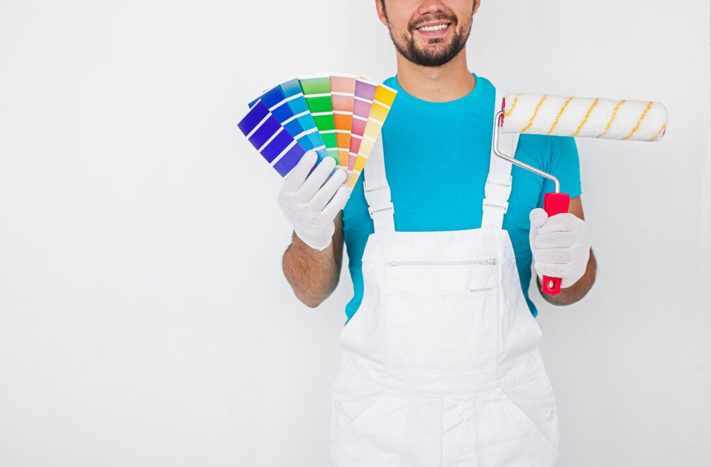 Male decorator with palette samples and paint roller